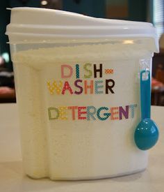 a plastic container with a blue spoon in it and the words dishwasher deterent written on it