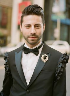 a man in a tuxedo standing on the street