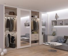 a living room filled with furniture and lots of closet space next to a white wall