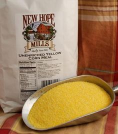 a scoop of yellow corn sits next to a bag of new hope mill's unwrapped yellow corn meal