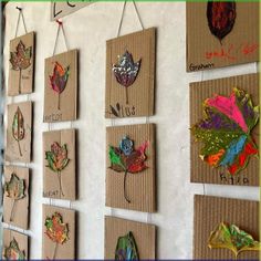 the wall is decorated with many different leaf shapes and numbers on cardboard boxes hanging from strings