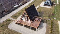 an aerial view of a small house with a deck on the front and back of it