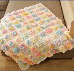 a crocheted blanket sitting on top of a couch