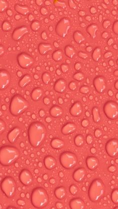 an orange object is sitting on top of some water droplets in red liquid with yellow dots