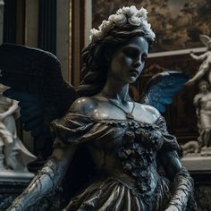 a statue with wings and flowers on it's head in front of some statues