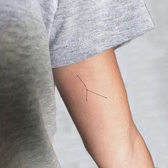 a woman's arm with a small arrow tattoo on the left side of her arm