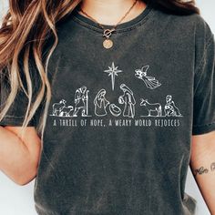 a woman wearing a t - shirt with the nativity scene on it