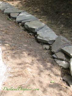 there is a stone wall in the dirt