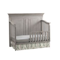 a baby crib with a white sheet on the bottom and a bed underneath it