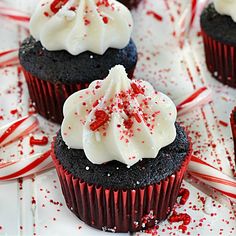 chocolate cupcakes with white frosting and red sprinkles