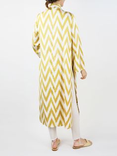 Our classic caftan duster. Inspired by the caftan garments of Uzbek royalty, the Fergana is designed with livable luxury in mind. Slits on the sleeve and the body of the caftan are created to highlight the jewelry and clothing that is worn underneath. Mandarin collar Sleeve and side slits Matching waist tie 100% silk ikat handwoven in Tashkent, Uzbekistan Tailored in Istanbul, Turkey Dry clean only Model is 5'11," wears size 10, and is wearing M/L. White Long Sleeve Kaftan For Daywear, Festive Long Sleeve Yellow Kaftan, Long Sleeve Dabka Kimono For Eid, Tashkent Uzbekistan, Silk Caftan, Silk Ikat, Istanbul Turkey, Mandarin Collar, Waist Tie