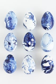 blue and white marbles arranged in a circle on a white surface with black spots