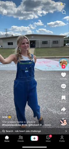 a girl in overalls is holding her arms out with one hand and smiling at the camera