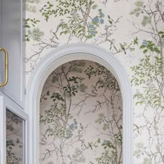 an arched window in a wallpapered room