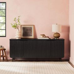 a living room with pink walls and white rugs on top of the carpeted floor