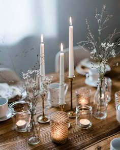 a wooden table topped with candles and dishes