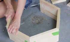 a person kneeling down next to some wooden boxes with holes in them on the ground