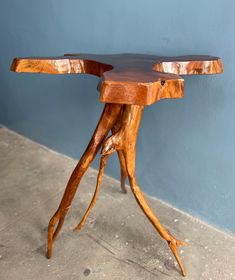 a wooden table that has been made to look like a tree trunk with curved legs