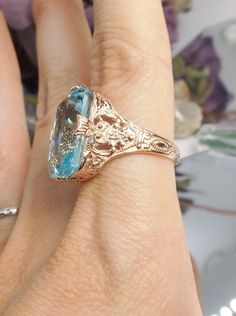 Simulated Aquamarine Rose Gold plated Sterling Silver Ring Treasure Design#D202 This is an Edwardian era reproduction filigree ring. The Art Deco design is beautifully created in rose gold plated solid sterling silver. This is a flawless man-made/simulated sky blue aquamarine that measures 18mm by 13mm. The ring is 3/4" (19mm) North to South on the finger. The inside of the band is etched 925 (sterling). Notice the intricate and detailed floral design. The rose gold 'embraced' silver filigree ac Gold Vintage Jewelry, Pig Jewelry, Paw Print Ring, Opal Stacking Ring, Hammered Gold Ring, September Birthstone Jewelry, Sterling Silver Stacking Rings, Dainty Gold Rings, Tiny Rings