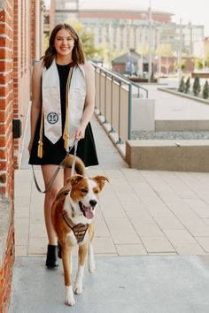 a woman is walking her dog down the sidewalk with it's tongue hanging out