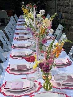 the table is set with pink and yellow flowers