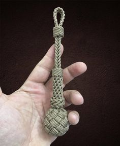 a hand holding a rope with a knot on it