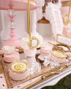 an elaborately decorated table with pink and gold items on it's trays