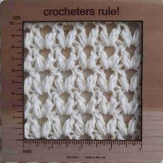 the crocheted square is shown in front of a ruler