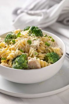 a white bowl filled with pasta and broccoli