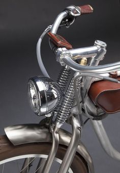 a close up view of the handlebars and seat on a motorcycle with a brown leather bag