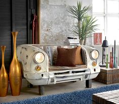 an old car is sitting in the living room next to a vase and bookshelf