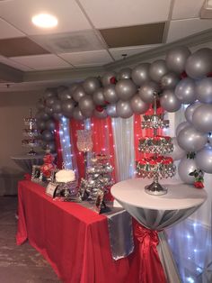 a table with silver and red balloons on it