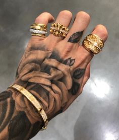 a person's hand with three different rings on it