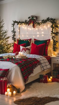 a bedroom decorated for christmas with red and green decorations on the headboard, plaid bedding, candles and blankets