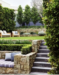 an outdoor area with stone steps leading to the lawn and seating areas on each side