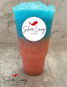 a blue and red drink sitting on top of a marble counter next to a white wall