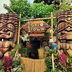 there is a tiki town sign surrounded by plants