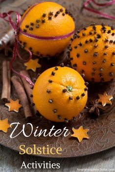 three oranges are sitting on a plate with cinnamon sticks and star decorations around them