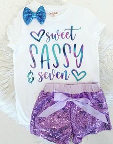 two pieces of purple and blue sequin shorts with bows on the side, white shirt that says sweet sassy & seven