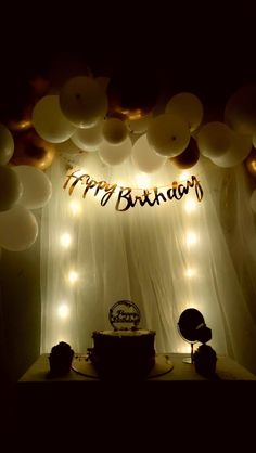 a birthday cake sitting on top of a table under balloons