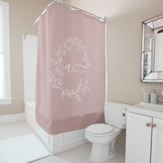 a bathroom with a pink shower curtain and white toilet