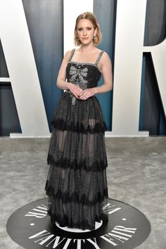 a woman in a black dress standing on a carpet with the words vanity written across it