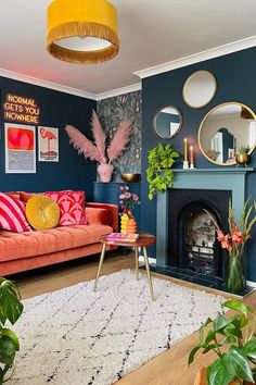 a living room filled with furniture and lots of plants on top of a wooden floor