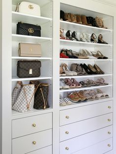 the closet is full of purses and handbags on shelves with white shelving