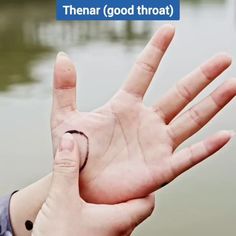 a person holding up their hand with the word mean written on it in front of a body of water