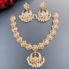 Featuring a harmonious floral pearl necklace with chandbali earrings in 22ct gold. The necklace set has been adorned with freshwater pearls. The weight of the necklace is 25.77 GMs including 1.58 GMs in hanging pearls. The earrings weigh 16.04 GMs including 3.14 in hanging pearls. Price Breakup Summary Component Rupees % of Total 22k Gold 188,778 76.4% Stones & Beads 17,134 6.9% Making Charges 33,980 13.8% Taxes (GST) 7,197 2.9% Total 247,089 100.0% View Detailed Price Breakup