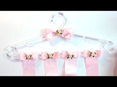 a pink bow tie hanger with four clips attached to it and hanging on a wall