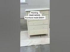 a white dresser sitting on top of a floor next to a sign that says fake wood furniture made easy