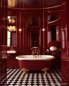 an ornate bathroom with red walls and black and white checkered flooring is shown