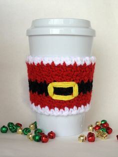 a coffee cup cozying with christmas decorations around it